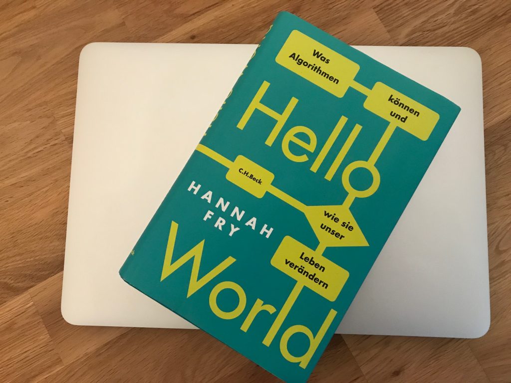 Buch mit dem Titel "Hello World - Was Algorithmen können und wie sie unser Leben verändern" von Hannah Fry, liegend auf einem Laptop